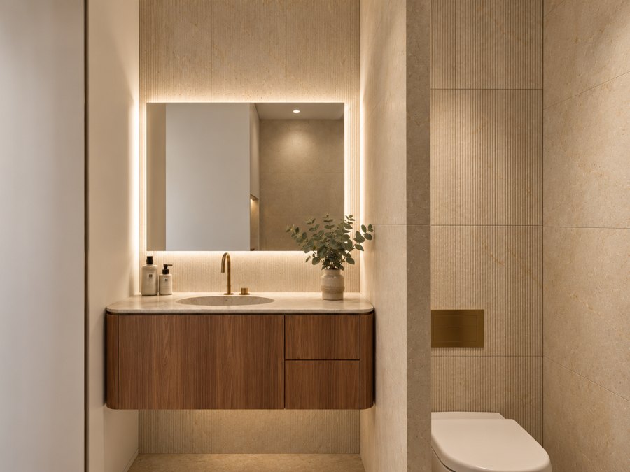 Baño de cortesía con mueble de nogal a medida diseñado por Arkitektismo